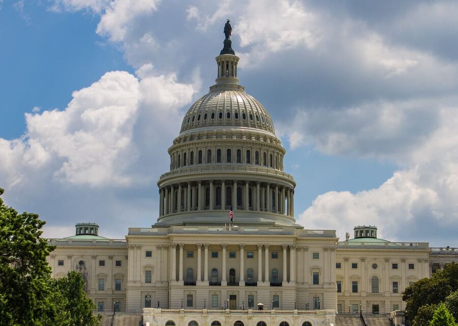 A federal government building exterior under a bright blue sky